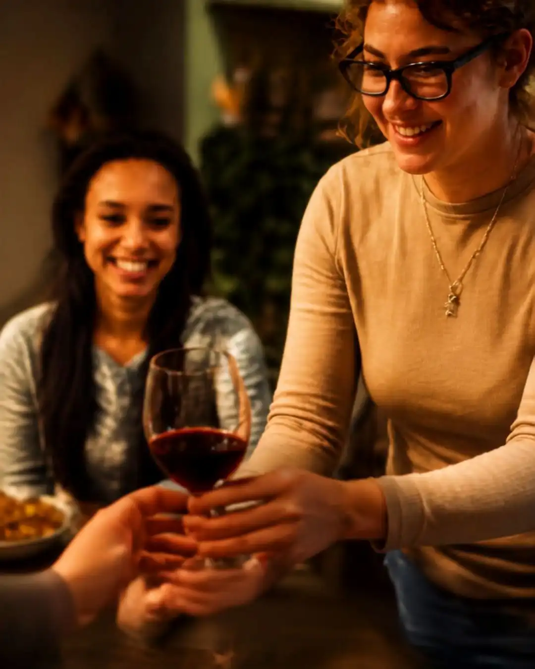 Rose & Crown team member serving a glass of red wine to a smiling guest