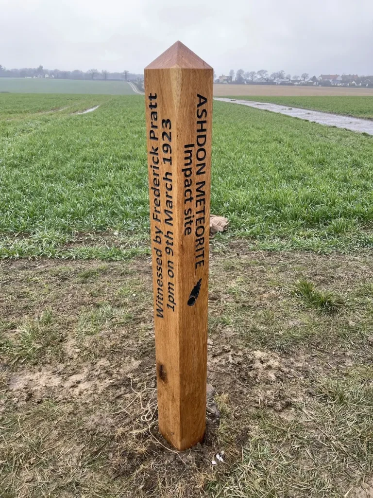 Carved oak marker post in a field south of Church End, Ashdon, inscribed "Ashdon Meteorite impact site – witnessed by Frederick Pratt, 1pm on 9th March 1923"