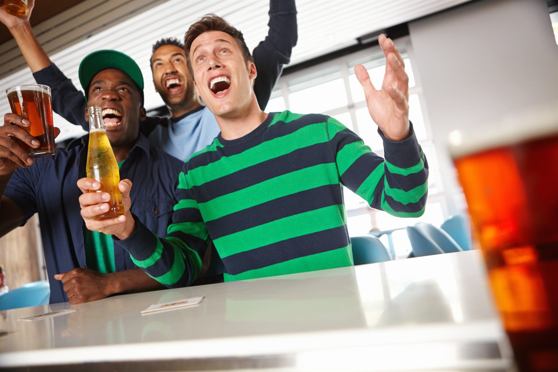 Rugby fans celebrating at the bar with pints Rugby fans celebrating at the bar with pints
