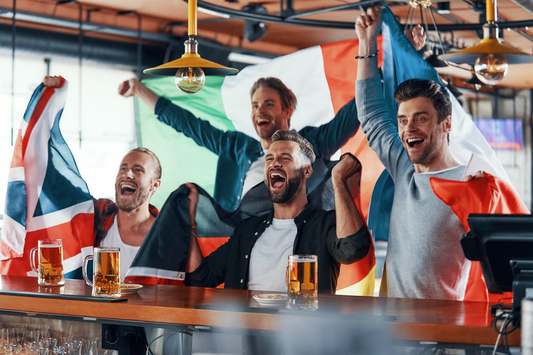 Fans with flags cheering a match in the pub Fans with flags cheering a match in the pub