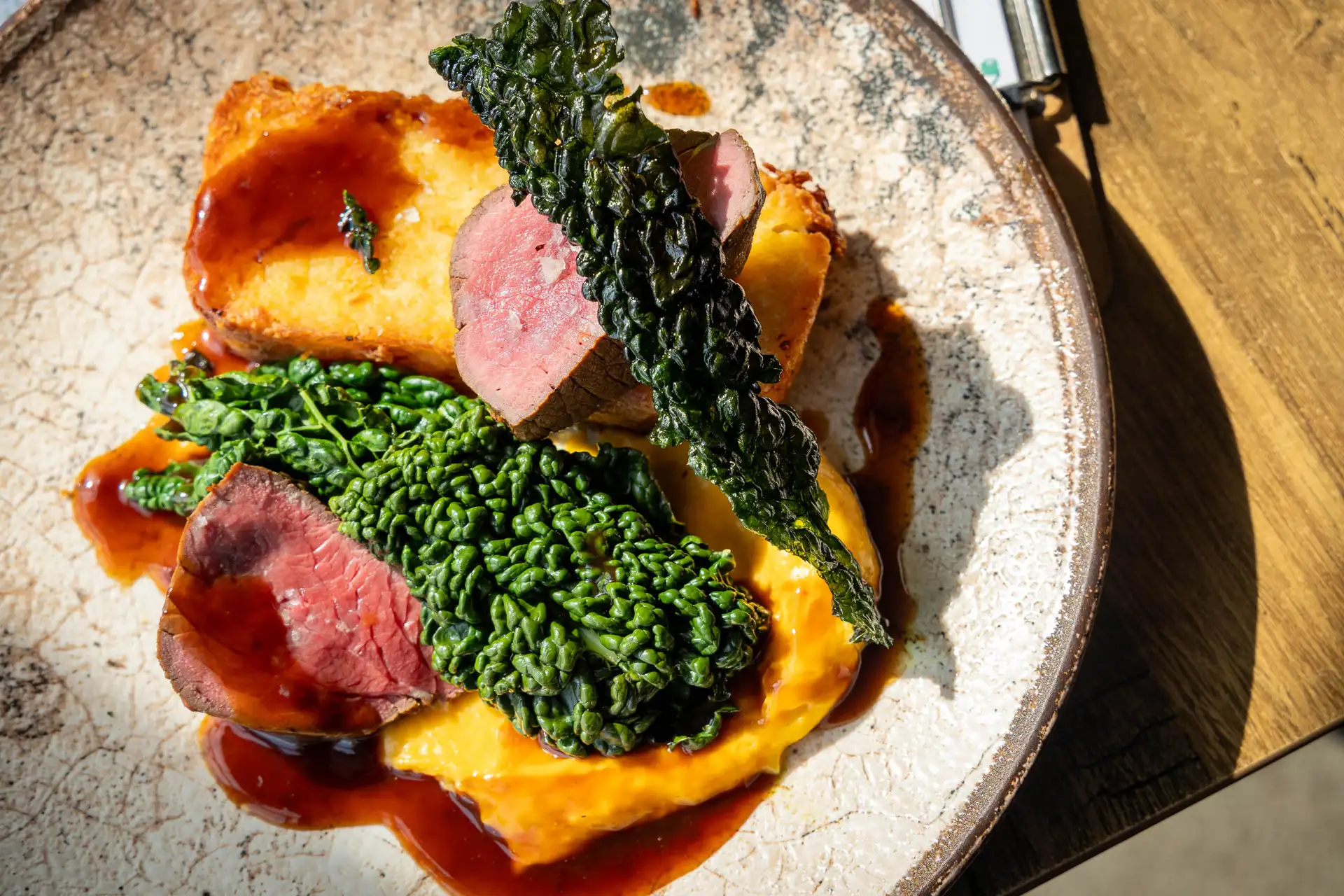 Treacle cured sirloin of Herefordshire beef with potato and horseradish rosti, cavolo nero, squash and nutmeg purée and bone marrow jus