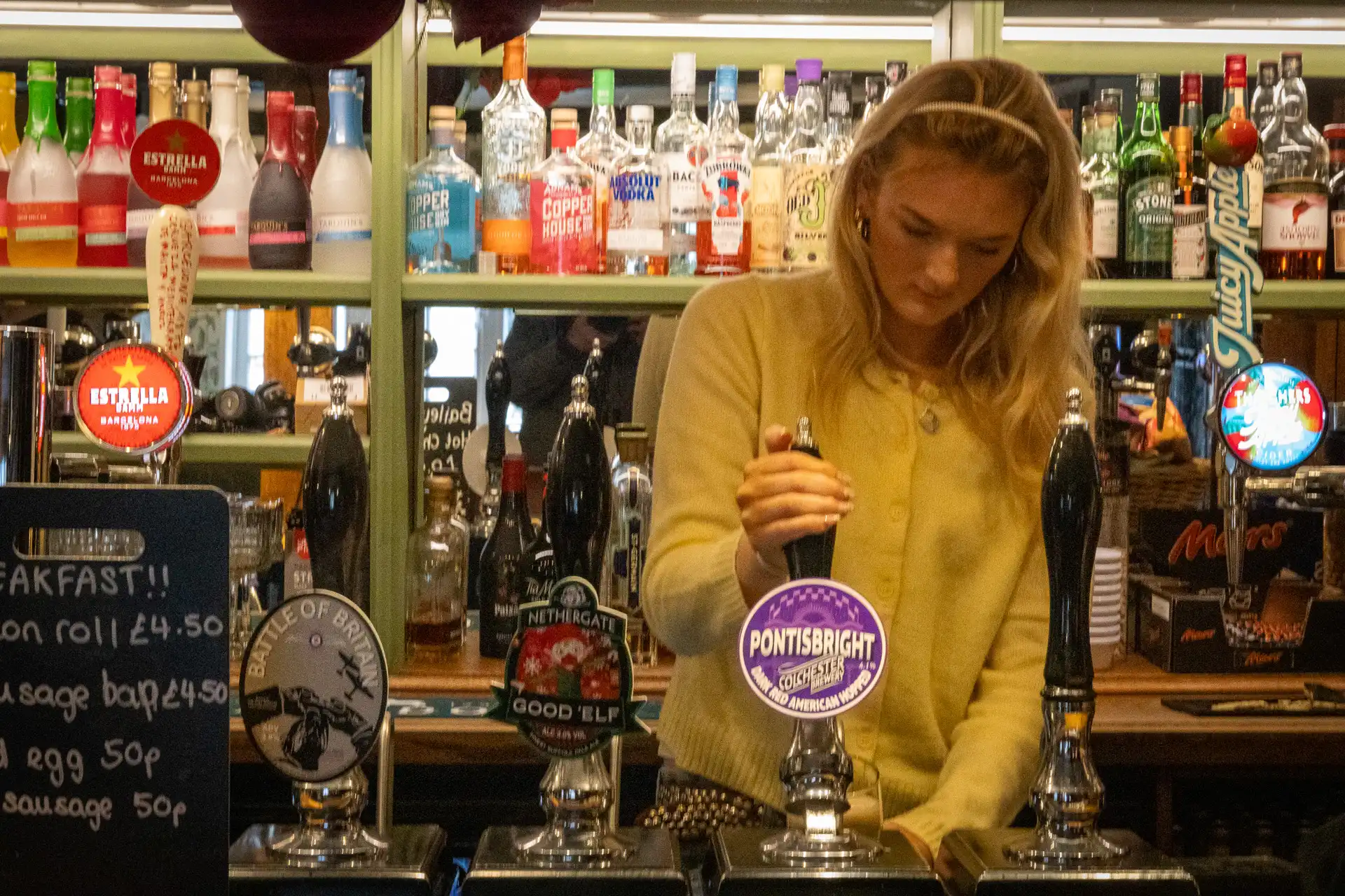 A pint being poured at the bar at the Rose & Crown, Ashdon, decorated for Christmas